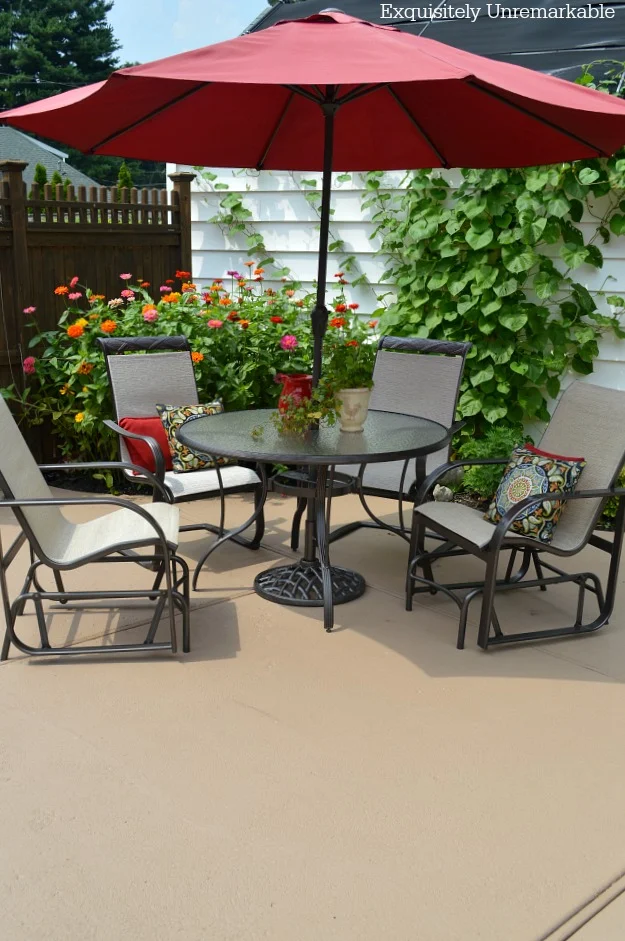 Red Market Umbrella patio set in a backyard garden