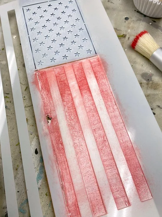 stenciling an American flag on a wooden stake
