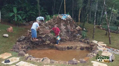 Execução do caminho com pedras em volta do lago com o muro de pedra em volta do lago, sendo caminho com pedra cacão de São Tomé com junta de grama.