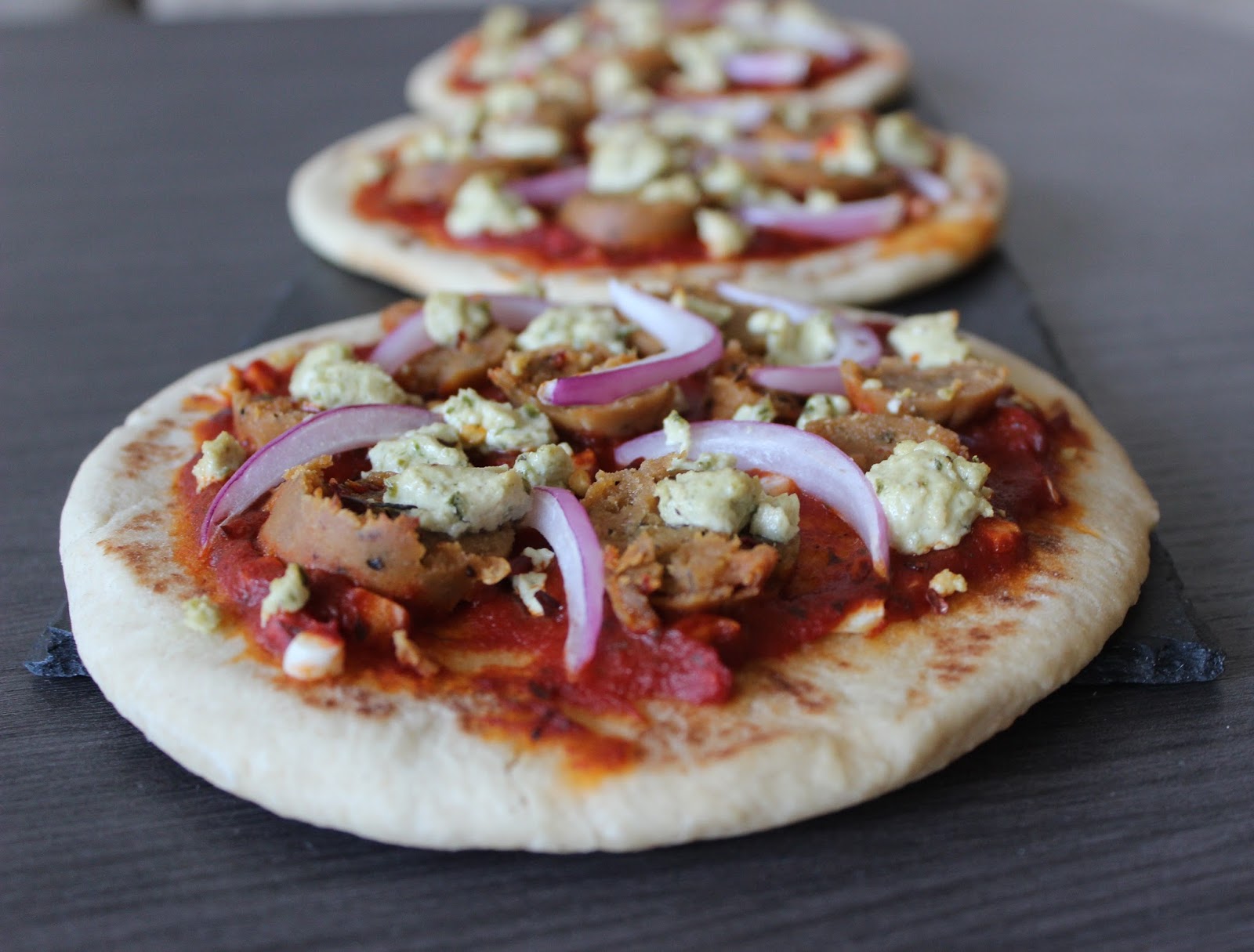 A Hoppy Medium Garlic Naan Pizzas with Goat Cheese, Sausage, and Onion