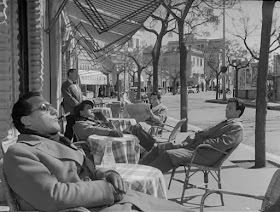 Sordi (in the foreground) lounges outside a cafe in I vitelloni