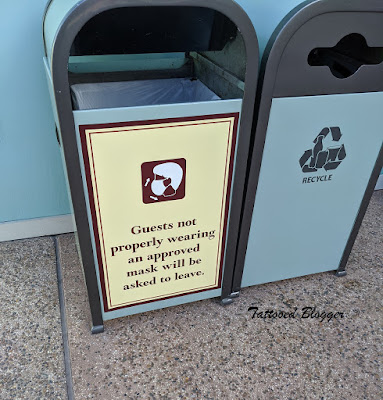 Trashcan at Disney springs with mask rules, sign on side