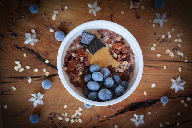 Porridge con muesli, arándanos, chocolate y crema de cacahuete