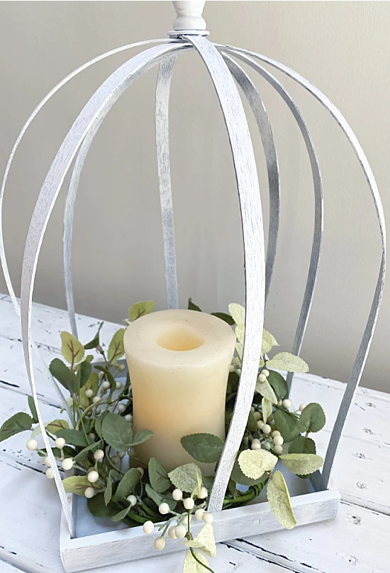 white lantern with wreath and candle