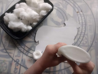 Toddler gluing cotton balls onto her farm sheep craft