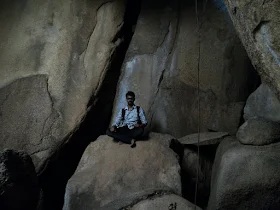 The narrow, dark opening under a boulder that marks the entrance to the Sidarabetta caves