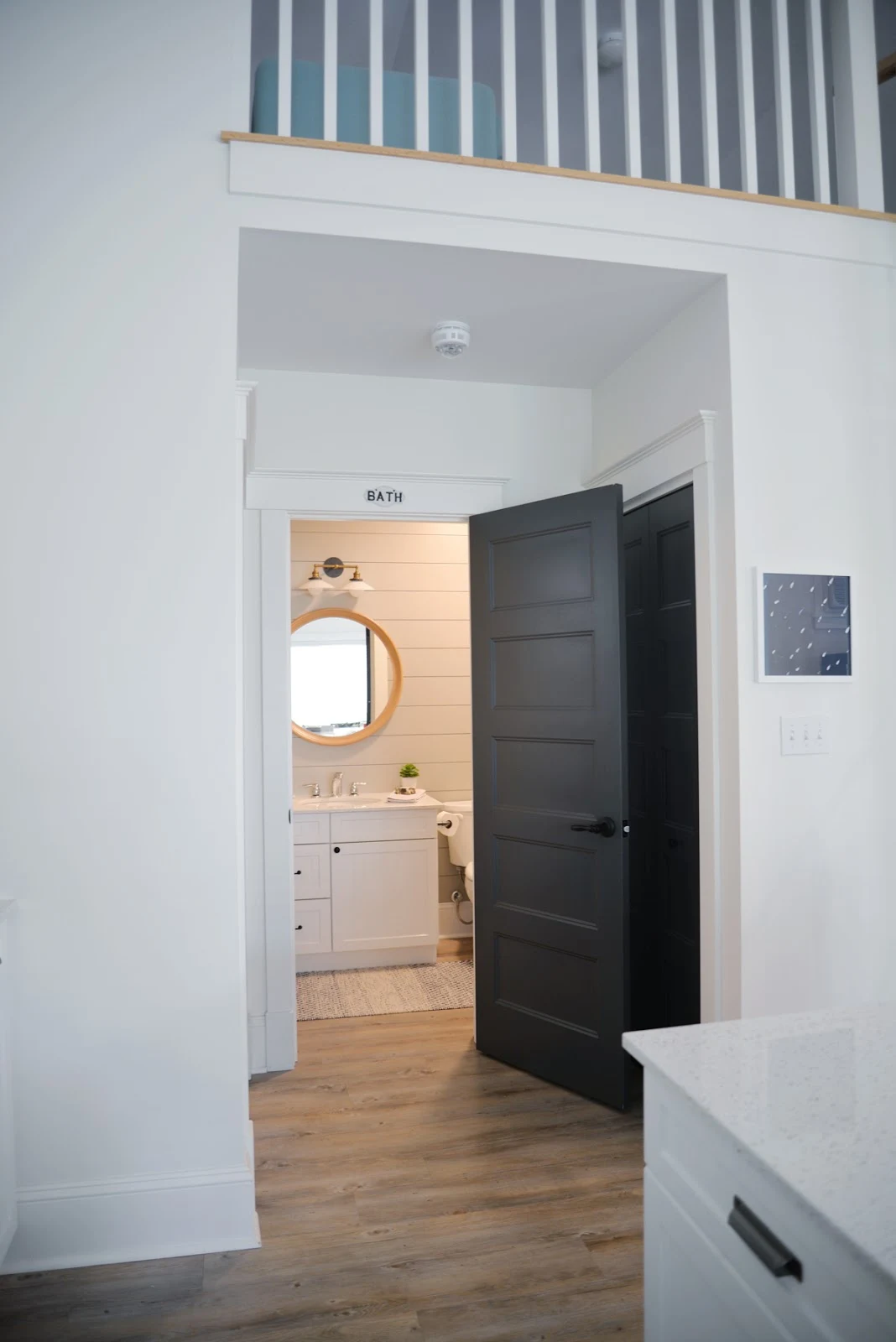 grey painted shiplap in the bathroom, round wood mirror, milk glass sconce | Ramblingrenovators.ca