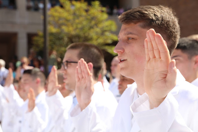 Ryan Craig featured in the foreground in a white coat.