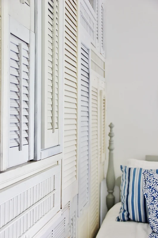 Old shutters wall art in a bedroom by Thistlewood Farms featured on I Love That Junk