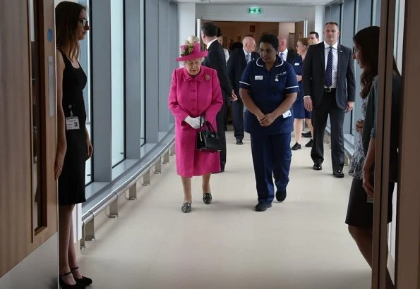 Queen Elizabeth wore a floral satin dress, pink coat and pink hat for visit National Institute of Agricultural Botany