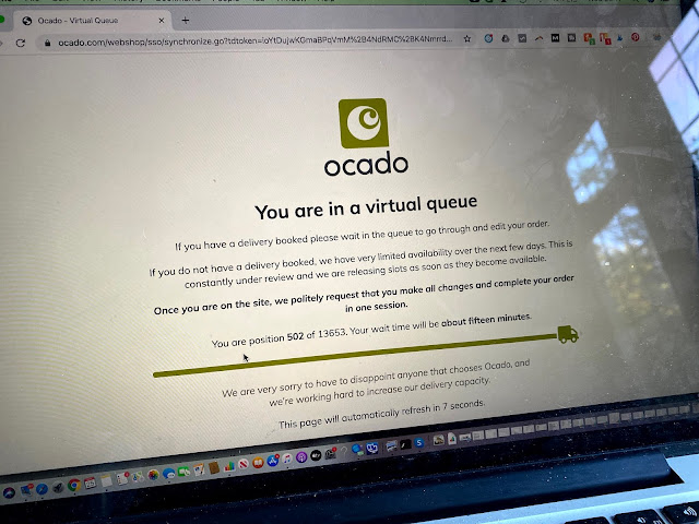 a photograph of a macbook screen with the Ocado virtual queue page at position 502 of 13653
