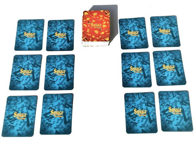 na zdjęciu karty królewien zakryte i rozłożone w czterech kolumnach po trzy karty a na środku stos zakrytych kart z czerwonym rewersem