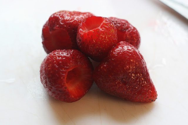 Hulled strawberries on a board. 