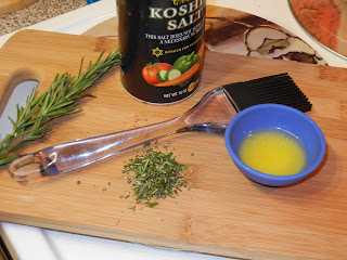 butter rosemary and salt on a cutting board with a baking brush 