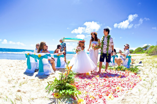 Hawaii beach wedding with flower girl holding her own bouquet