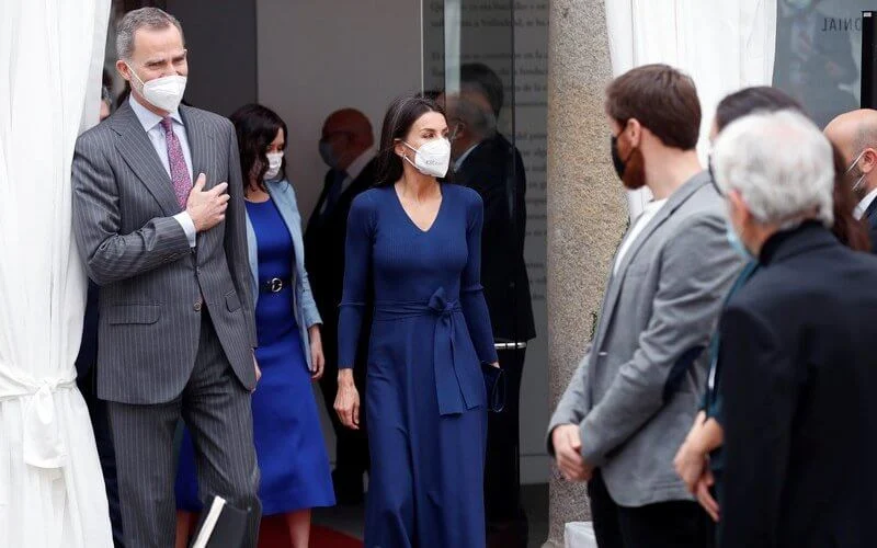 Queen Letizia wore a navy belted wool v-neck midi dress from Massimo Dutti, and white cashmere coat from Carolina Herrera