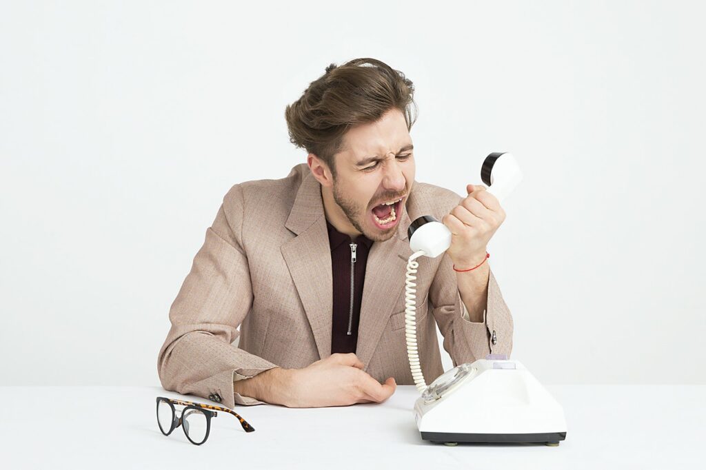 Homem irritado falando ao telefone Homem irritado falando ao telefone