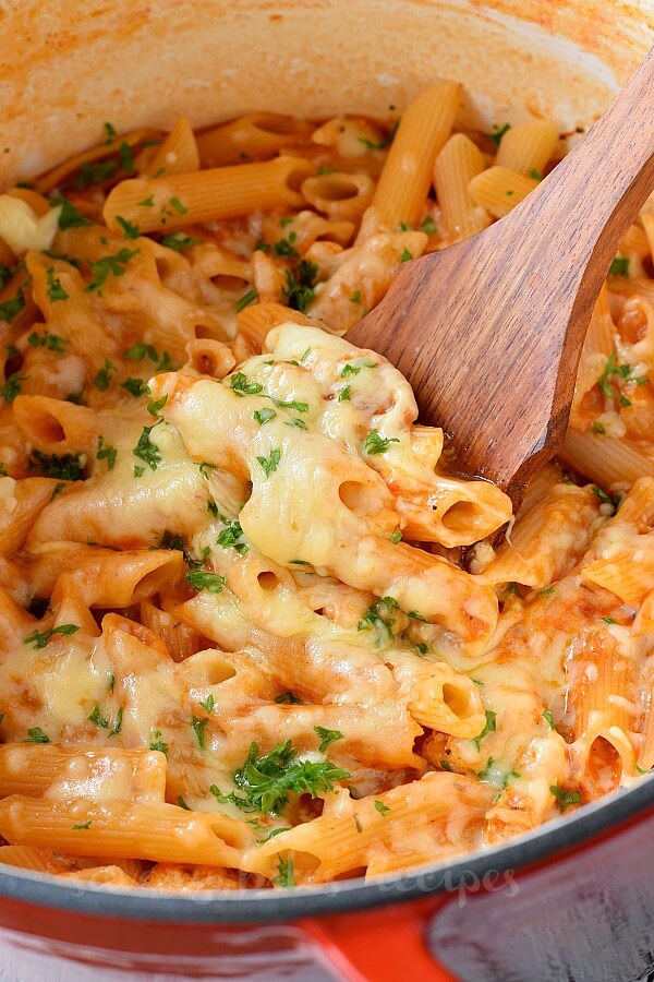 a pot with wooden ladle and chicken parm pasta