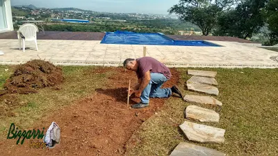 Bizzarri, da Bizzarri Pedras, marcando com estacas onde vamos fazer os caminhos de pedra Carranca com junta de grama em casa em condomínio em Atibaia-SP. 5 de junho de 2017.