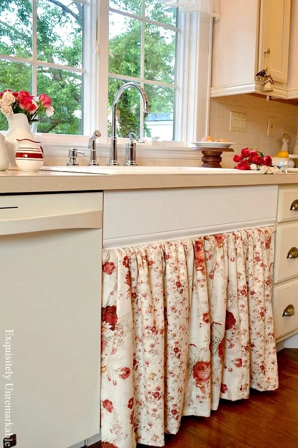 Cottage style floral kitchen sink skirt in off white kitchen with flowers in vases