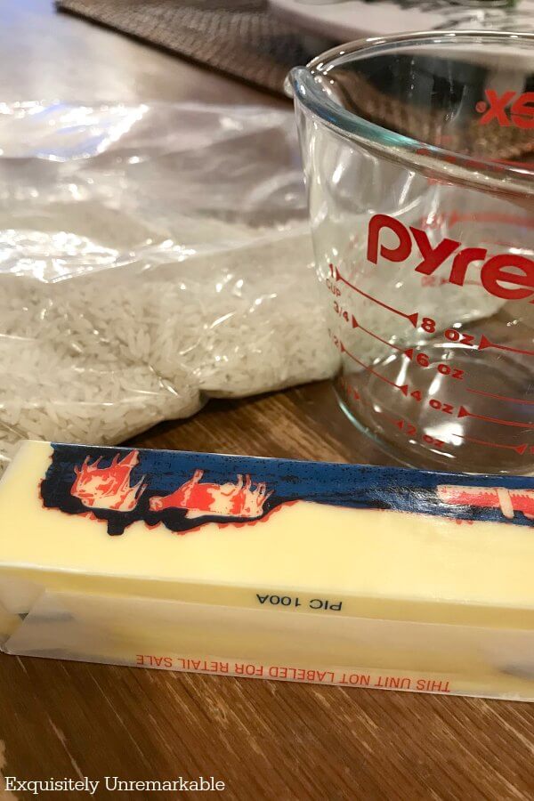Butter, Pyrex measuring cup and dry rice on table