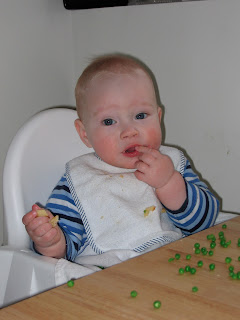 Baby feeding himself peas (maybe)