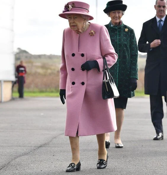 Queen Elizabeth wore a pink coat by Stewart Parvin and matching hat by Rachel Trevor-Morgan. Carved Ruby, gold and diamond brooch, Grima ruby brooch