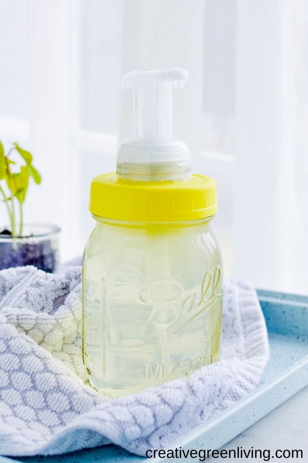 How to make a DIY foaming soap dispenser that you refill at home. Use a glass mason jar to get an adorable farmhouse look. Make one of these cute soap dispensers for the bathroom and the kitchen. This tutorial shows you the best way to make your own foaming soap dispenser step-by-step by using a plastic lid to avoid rust. #foamingsoap #masonjar #farmhouse
