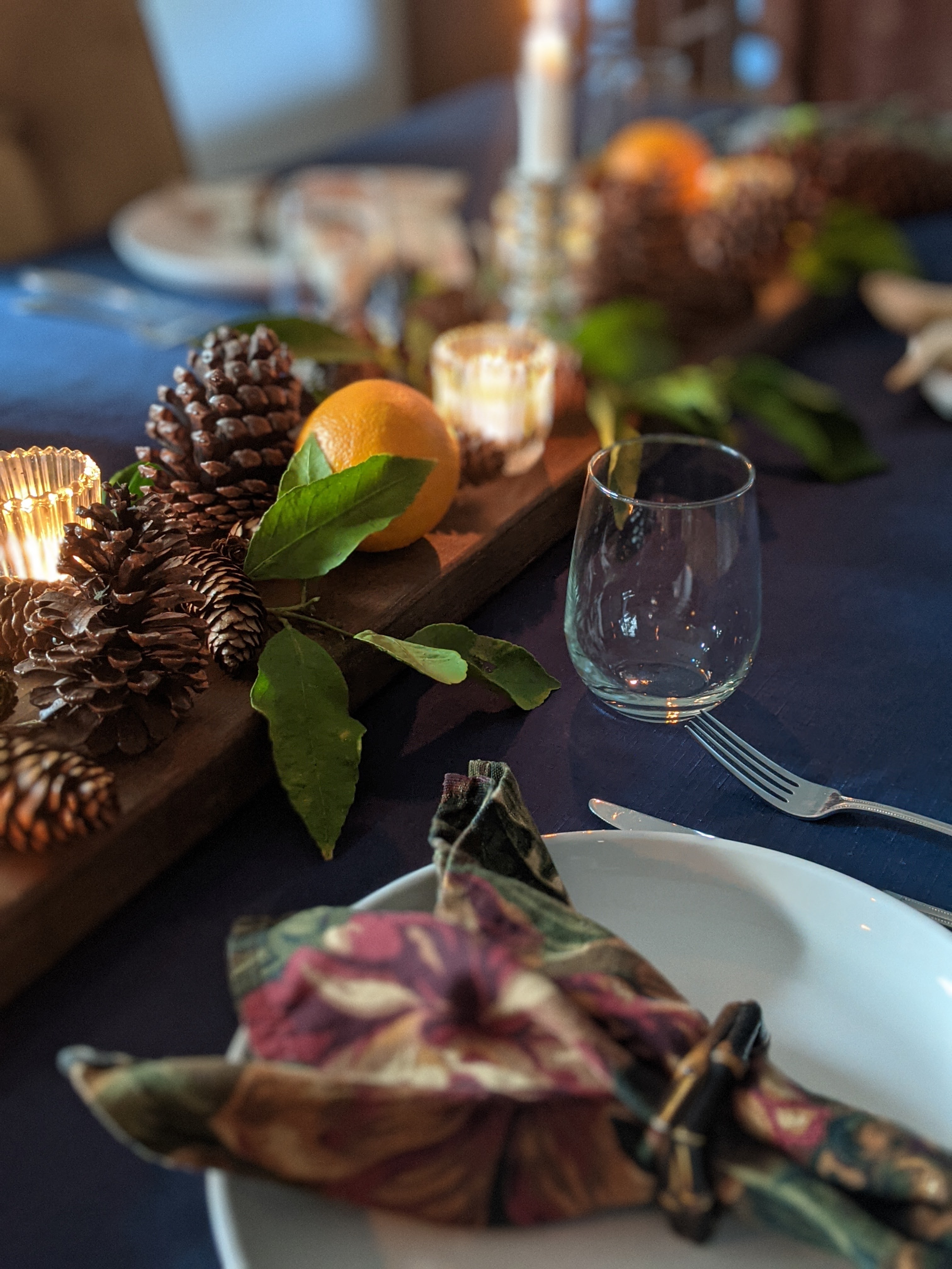 CAD Interiors dining table setting holidays fruit lemons pinecones pine garland candles natural