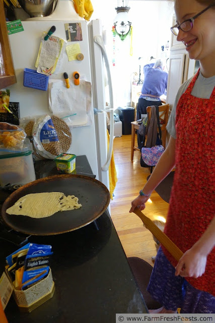 My Mother's Lefse #ChristmasWeek | Farm Fresh Feasts | http://www.farmfreshfeasts.com/2014/12/my-mothers-lefse-christmasweek.html photo of a misshapen piece of lefse cooking on the griddle