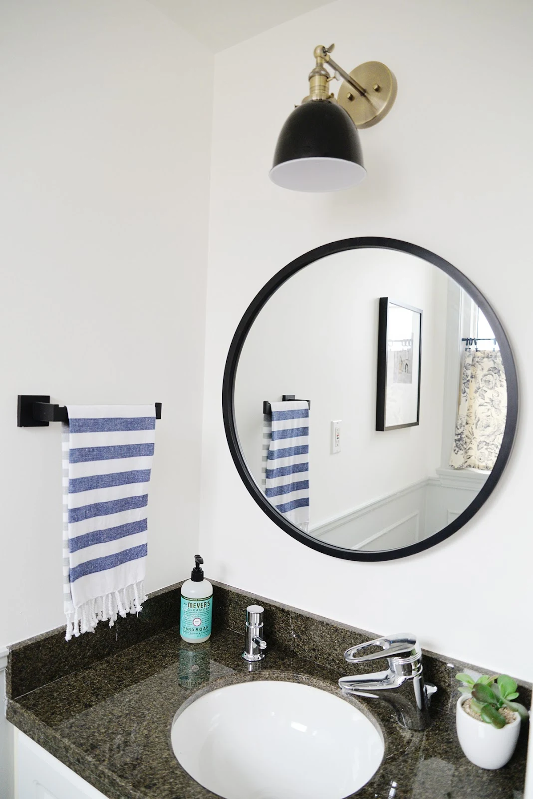 small powder room, round bathroom mirror, amazon sconce
