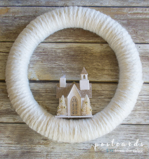 white knit wreath with small house