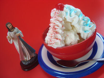 Sundae with cherry on top and two whipped cream lines one with red and one with blue sprinkles