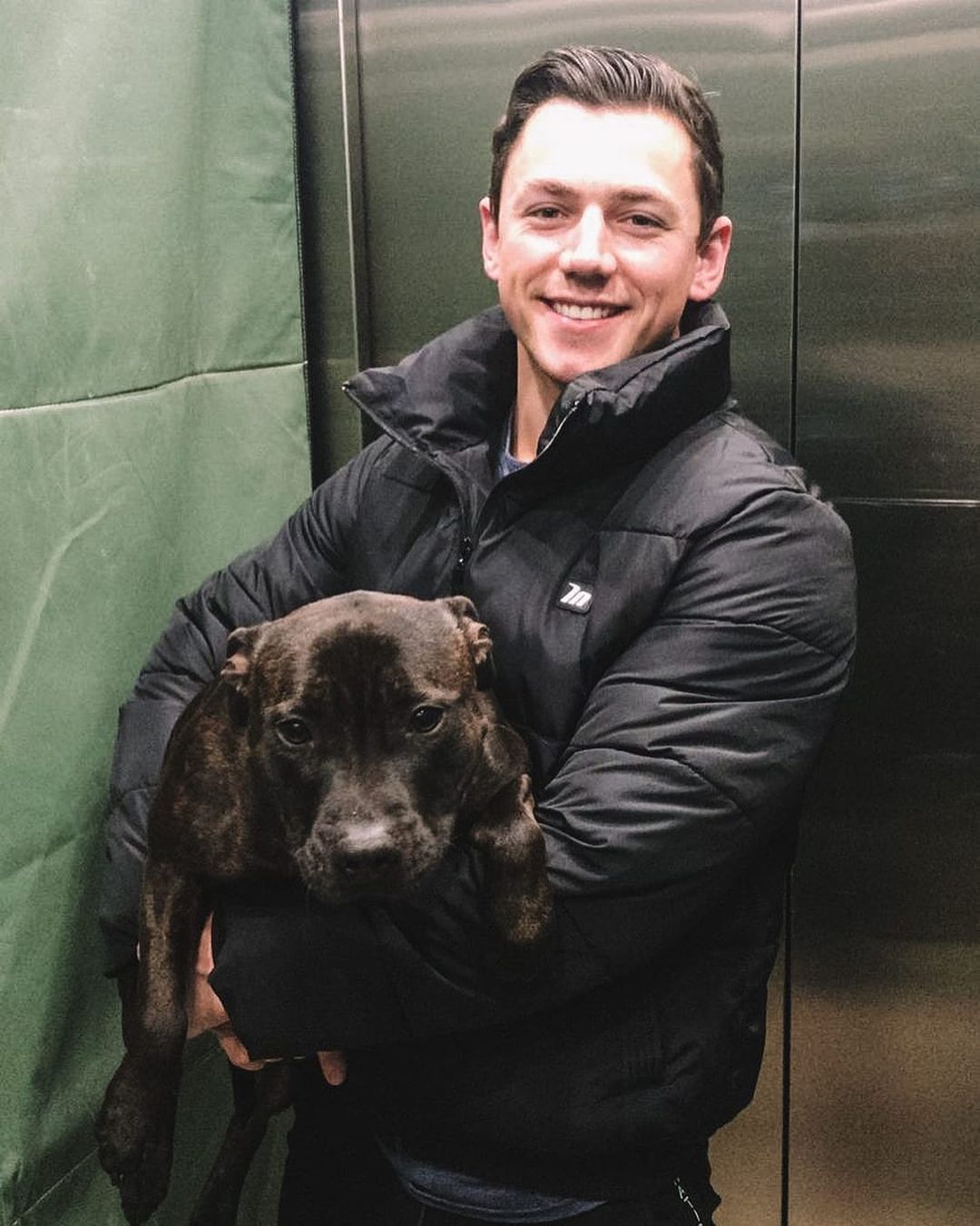 straight-handsome-neighbor-smiling-elevator-ride-holding-dog