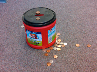 picture of coffee can with slit cut in lid with collection of pennies for an easy coin drop