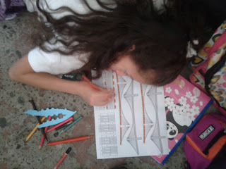 niña pinta moldes de estructuras en papel puente broklin