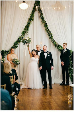 K'Mich Weddings - wedding planning - bride and grooms holding hands in the air after ceremony