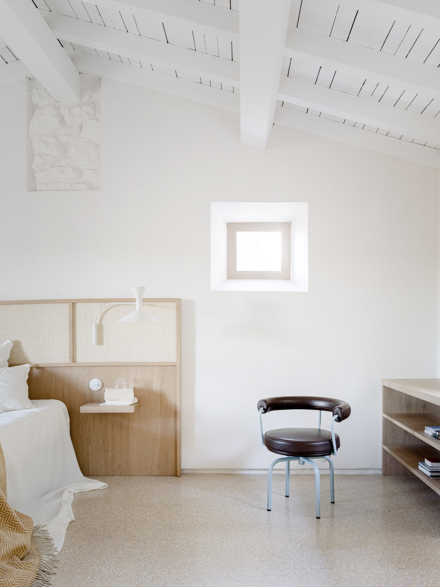 headboard in wood and raffia, white walls in a minimal bedroom