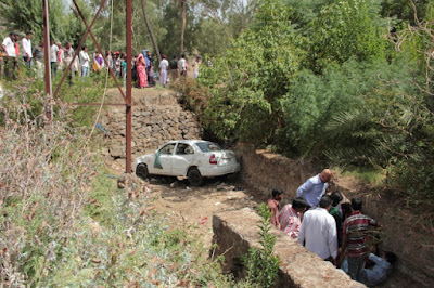 'A tourist car overshot and landed in the stream, Abuites gathered around to help the passangers.",