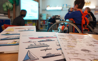 Primeiro plano das placas com os vários tipos de barcos e peixes