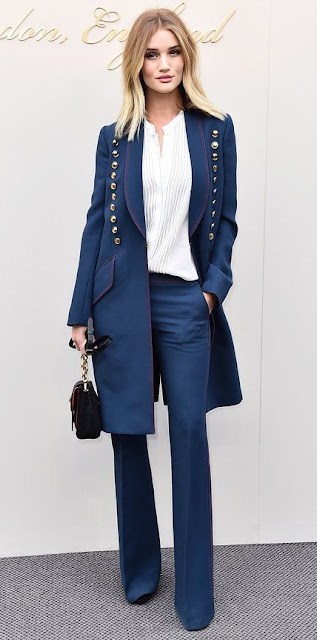 Look do dia de Rosie Huntington Camisa branca plissada, calças azuis, casaco azul com botões dourados e uma mini-bag Look do dia de Rosie Huntington Camisa branca plissada, calças azuis, casaco azul com botões dourados e uma mini-bag