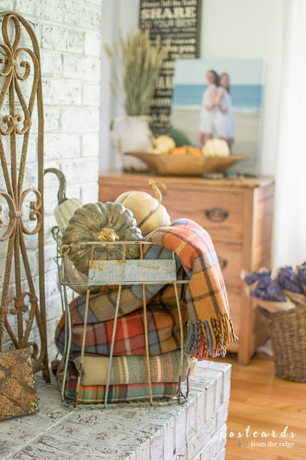 plaid scarves in a vintage wire egg basket, on a fireplace mantel