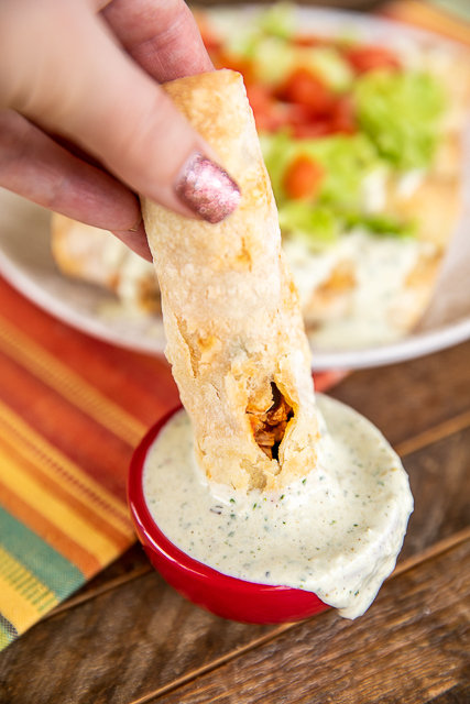 Air Fryer Chicken & Black Bean Taquitos - SO simple and they are seriously delicious! The whole family loved them! Shredded chicken, salsa, black beans, and cheese rolled up in corn tortillas and baked in the air fryer. Can use flour tortillas if preferred. Can freeze taquitos for a quick meal later! These homemade Mexican chicken taquitos were a HUGE hit in our house! #taquitos #airfryer #chicken #mexican dipping baked chicken taquitos into jalapeno dip