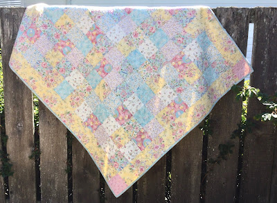 A simple pastel quilt made from charm squares A simple quilt made from five inch charm squares