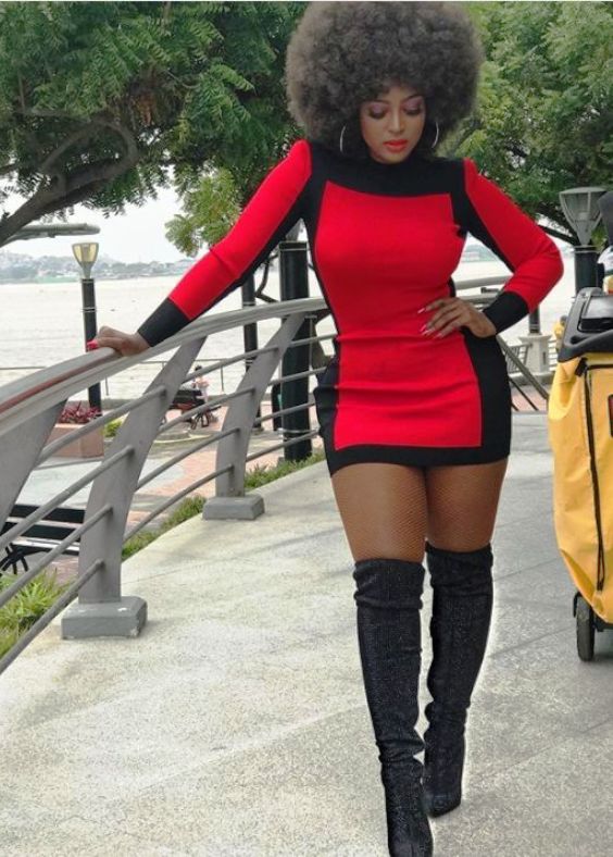 Woman in a red mini dress, nude tights and black boots
