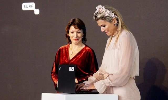 Queen Maxima wore a light baby pink tulle top and pink wide leg trousers. Salvatore Ferragamo flower heel pump shoe