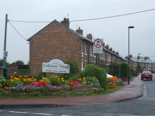 A sign by the road saying Callerton Village