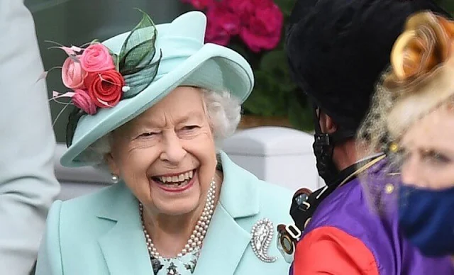 Queen Elizabeth wore an aquamarine coloured coat and dress and a matching hat adorned with pink flowers. Palm Leaf brooch