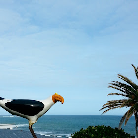 View of the sea, with a slightly deranged-looking wooden seagull in the foreground.