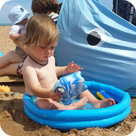 watering can in paddling pool, paddling pool at the beach